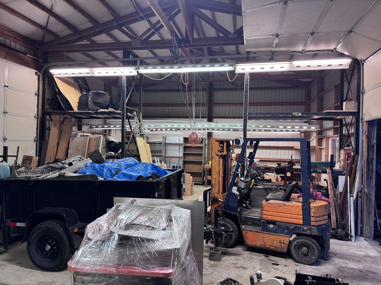 Forklift and loaded dump trailer during a shop cleanout by High Desert Hauling