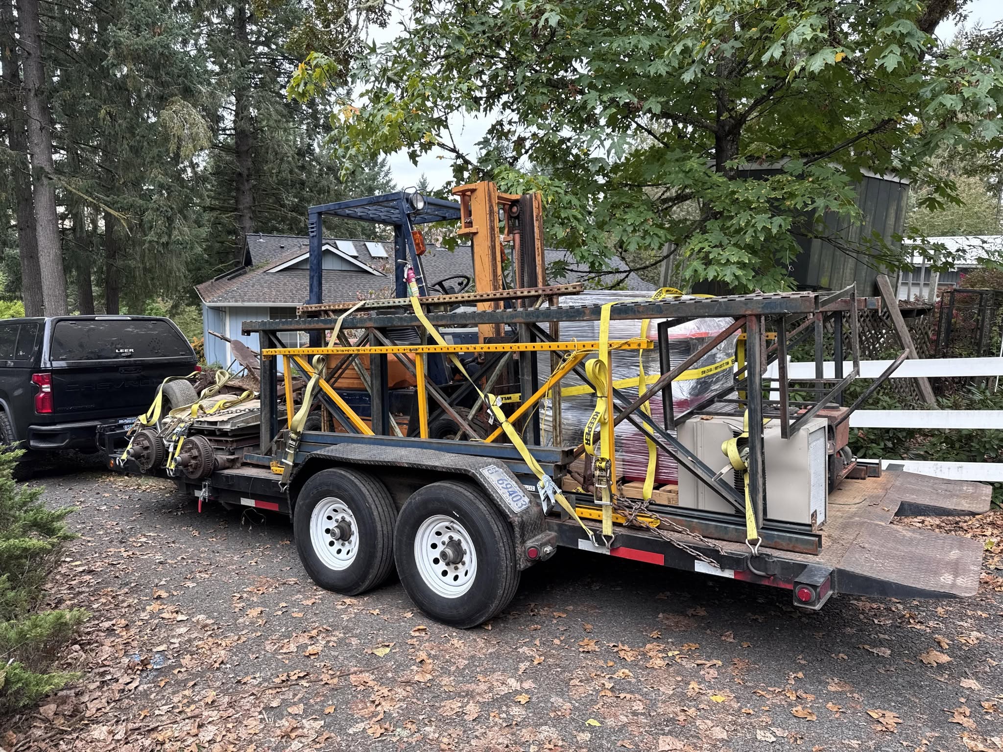 Heavy equipment and materials strapped down on the High Desert Hauling flatbed trailer for a big haul