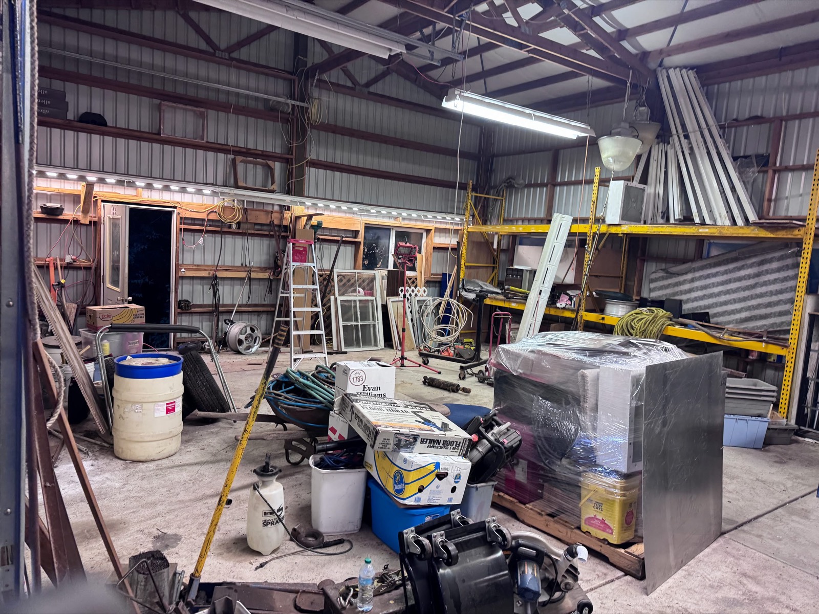 Cluttered shop packed with junk, tools and debris before a High Desert Hauling cleanout